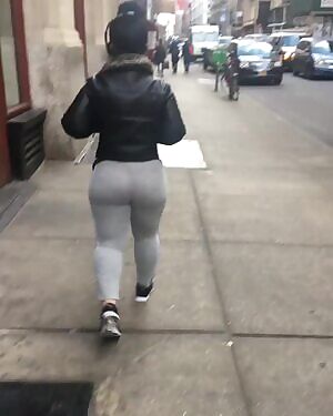 Thick lady in leggings walking down the street.