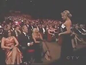 Pamela Anderson and Trish Stratus kiss during an awards show in 2006.