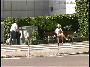 On a bench next to a bank almost topless